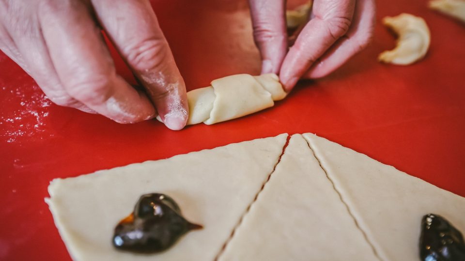 Díl smotáme od širšího kraje směrem do středu. Vznikne rohlíček, který ohneme do obloučku a jeho špičky zamáčkneme rukou