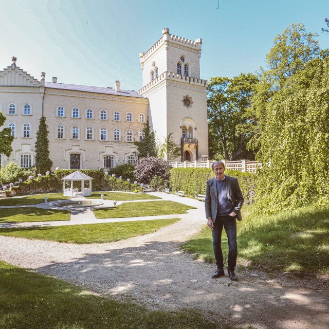 Majitel zámku Chyše Vladimír Lažanský před hlavní fasádou a zámeckým parkem | foto: Jana Volková